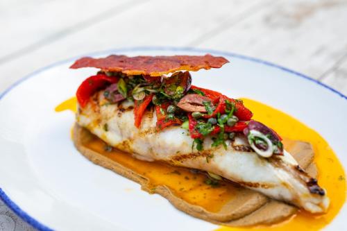 a piece of fish on a plate with sauce at The George Hotel and Beach Club in Yarmouth