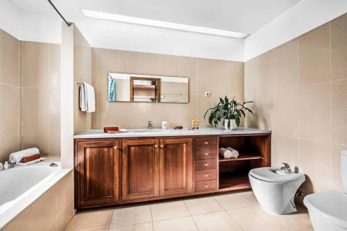 a bathroom with a sink and a tub and a toilet at Villa Mar Ali - JACUZZI - 400m from the beach - BY BEDZY in Albufeira