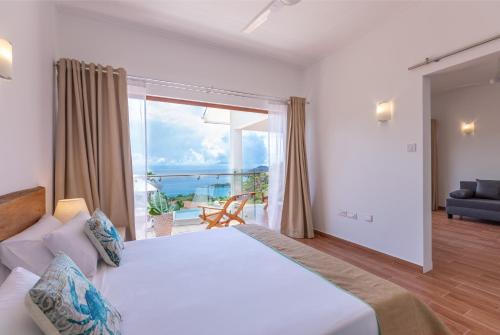 a bedroom with a large bed with a view of the ocean at Terrasse Sur Lazio in Anse Lazio