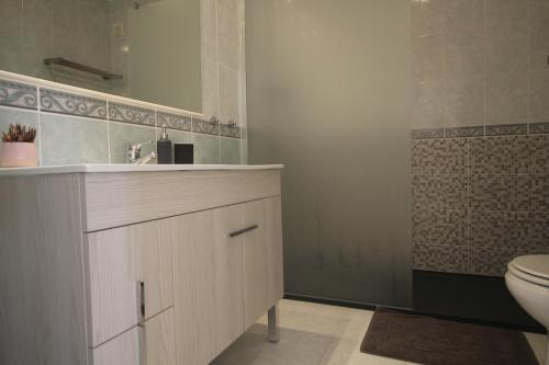 een badkamer met een wastafel, een toilet en een spiegel bij Manta Azul in Manta Rota