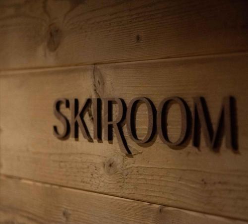 a sign on a wooden wall with the word skagen at La Ferme in La Clusaz