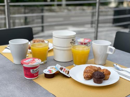 a table with a plate of donuts and orange juice at Hotel Stella Alpina in Malcesine
