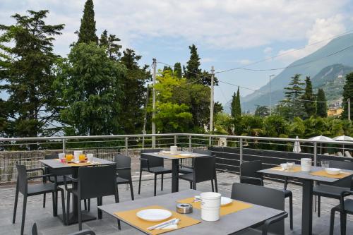 a restaurant with tables and chairs on a balcony at Hotel Stella Alpina in Malcesine
