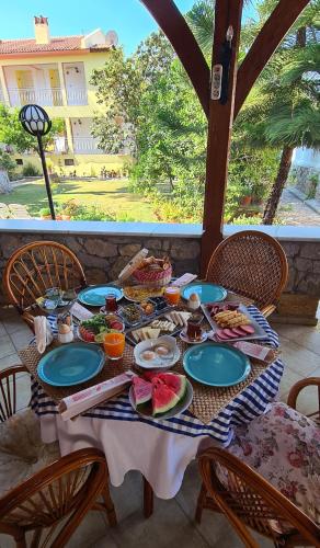 a table with plates of food sitting on a porch at İlkiz Beach Hotel in Oludeniz