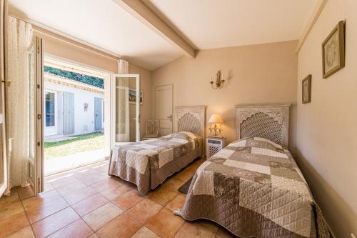 a bedroom with two beds and a large window at Jade En Provence in Vaison-la-Romaine