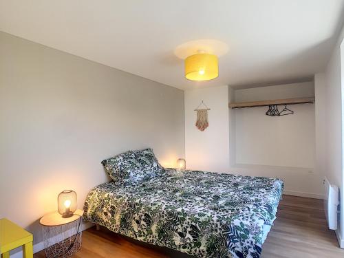 a small bedroom with a bed and two lamps at Maison 6 pers proche centre ville in Bréhal
