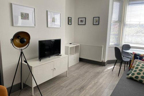 a living room with a flat screen tv on a dresser at The Four Bays Apartment - Cliftonville Central - By Goldex Coastal Breaks in Kent