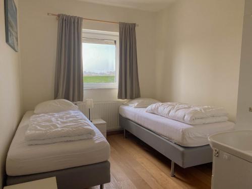 2 Betten in einem Zimmer mit Fenster in der Unterkunft Hello Zeeland - Appartement Port Scaldis 19-012 in Breskens
