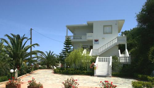 una casa blanca con una pasarela delante de ella en Villa Irini, en Almyrida