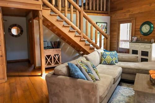 a living room with a couch and a staircase at Experience Louisiana, Cabin on Bayou Petite Anse in New Iberia