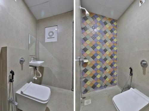 a bathroom with a shower and a toilet and a sink at Hotel Kuber in Dwarka
