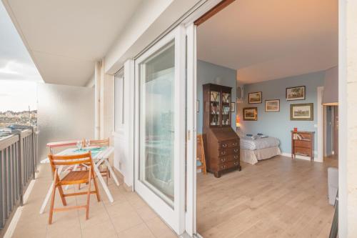 un salon avec une table et une chambre dans l'établissement Le Christina, à Trouville-sur-Mer