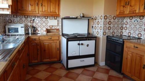 uma cozinha com um fogão preto e branco em The Bungalow em Doonbeg