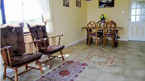 a living room with a dining room table and chairs at The Bungalow in Doonbeg