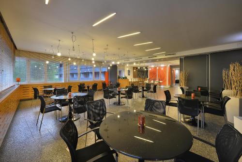 a restaurant with tables and chairs in a room at Omnia Hotel Relax & Wellness in Janske Lazne