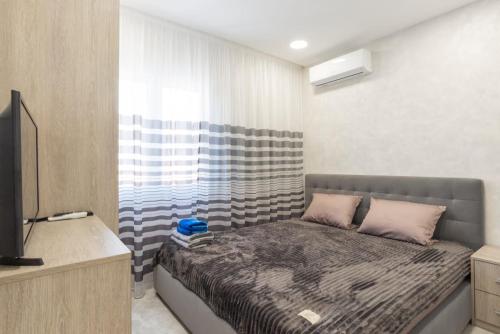 Dormitorio pequeño con cama y TV en Dream House Rooms Malaga - Habitacion en el apartemento, en Málaga