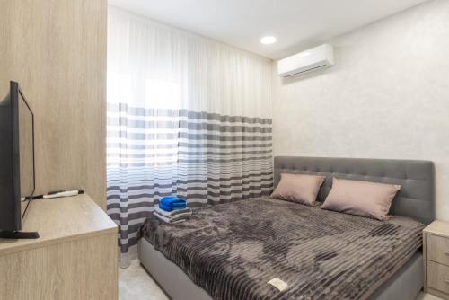 マラガにあるDream House Rooms Malaga - Habitacion en el apartementoの小さなベッドルーム(ベッド1台、テレビ付)