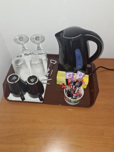 a tray with a tea pot and glasses on a table at Luca's House ( aeroport Henry Coanda, Therme Bucuresti) in Baloteşti