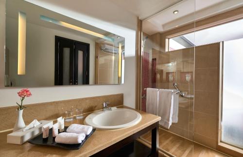 
a bathroom with a sink, mirror and bath tub at Mövenpick Resort Aswan in Aswan
