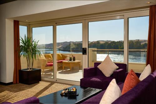 
a living room filled with furniture and a view of the ocean at Mövenpick Resort Aswan in Aswan
