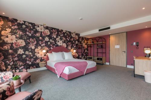 a bedroom with a pink bed and a floral wall at Van der Valk Hotel Venlo in Venlo