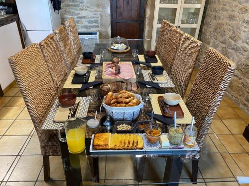 een tafel met ontbijtproducten en drankjes erop bij Chambres et table d'hôtes Le cèdre Aveyron in Sainte-Croix