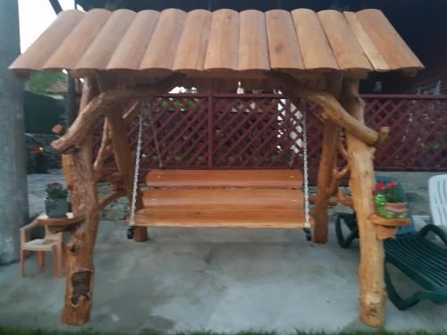 a wooden gazebo with a wooden bench at Cabana Beea in Dubova