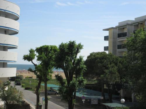 a view of a street with trees and a building at Appartamenti Katja in Bibione