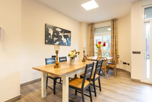 a dining room with a wooden table and chairs at Duplex de lujo en la playa , jacuzzy, piscina, chimenea y padel in Benalmádena