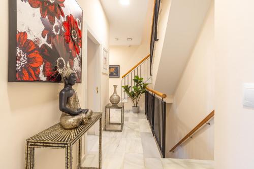 a staircase with a statue sitting on a bench in a hallway at Duplex de lujo en la playa , jacuzzy, piscina, chimenea y padel in Benalmádena