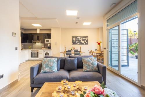 a living room with a couch and a table at Duplex de lujo en la playa , jacuzzy, piscina, chimenea y padel in Benalmádena