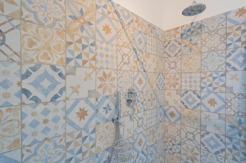 a bathroom with a shower with blue and white tiles at Acqua Chiara Apartment by Rent All Como in Dongo