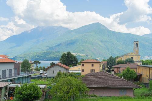 a town with mountains in the background and a town with houses at Acqua Chiara Apartment by Rent All Como in Dongo