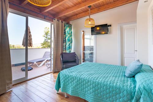 ein Schlafzimmer mit einem grünen Bett und einem Balkon in der Unterkunft Duplex de lujo en la playa , jacuzzy, piscina, chimenea y padel in Benalmádena