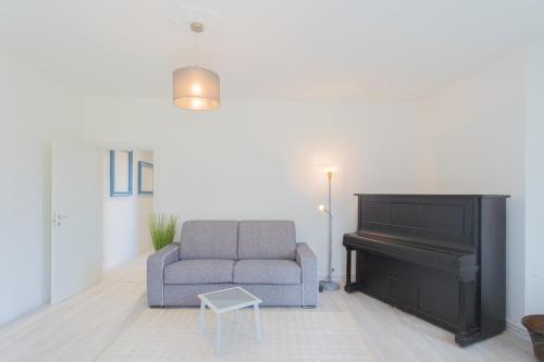 a living room with a couch and a piano at Acqua Chiara Apartment by Rent All Como in Dongo