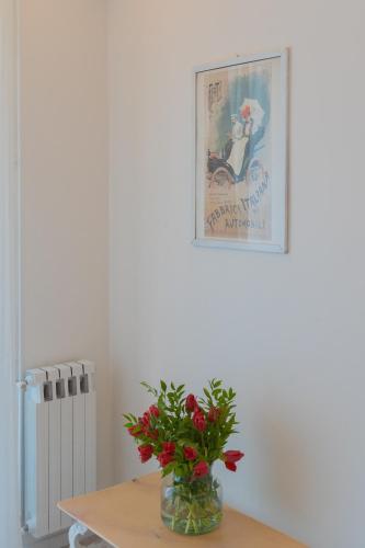 a vase of flowers on a table with a picture at Acqua Chiara Apartment by Rent All Como in Dongo