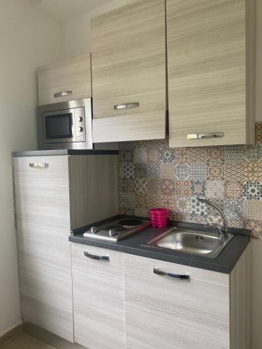 a kitchen with a sink and a microwave at La Dépendance di Zio Giovanni in Anacapri