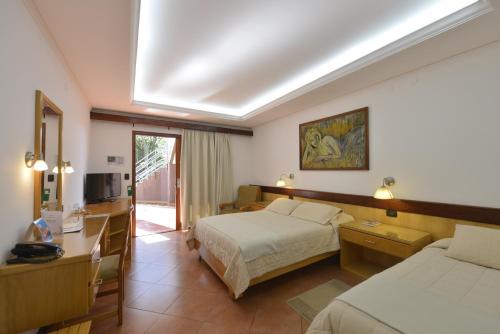 una camera d'albergo con due letti e una televisione di Hotel Restaurant Papillon a Bella Vista
