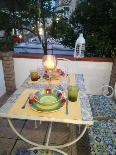 a table with a candle and plates on it at La Dépendance di Zio Giovanni in Anacapri