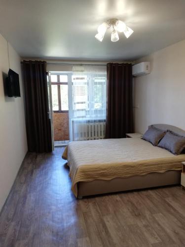 Un dormitorio con una cama grande y una ventana en Аренда квартиры, en Izmaíl