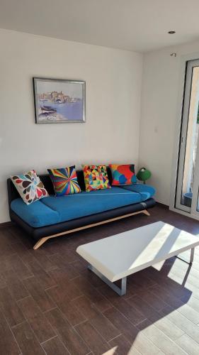 a living room with a blue couch and a coffee table at F2 rez de jardin in Ajaccio