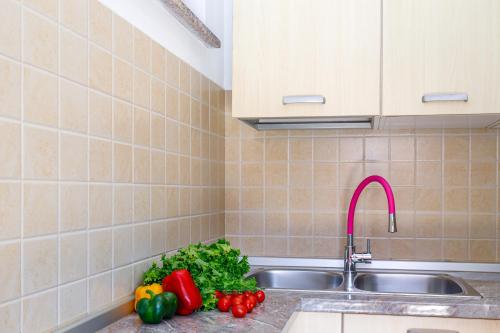 una cocina con fregadero y verduras en la encimera en Apartments Kiki 150 METERS TO THE BEACH, en Banjole
