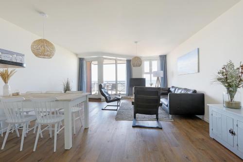 a kitchen and living room with a table and chairs at DE TRINTEL met zeezicht in Egmond aan Zee