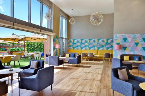 a restaurant with blue chairs and tables and windows at Avani Ibn Battuta Dubai Hotel in Dubai