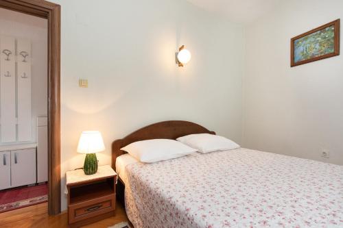 Un dormitorio con una cama y una lámpara sobre una mesa. en Oldtown 2, en Baška