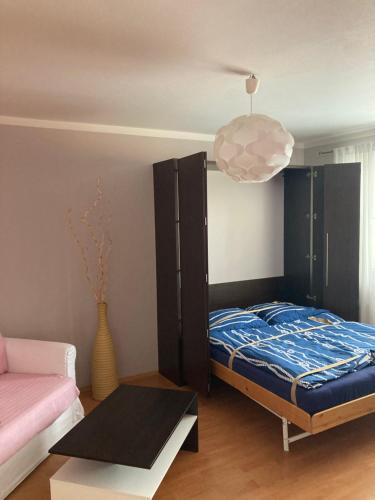 a bedroom with a bed and a pendant light at Apartmán Edita in Velké Losiny