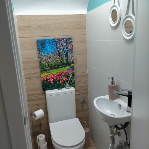 a bathroom with a toilet and a painting on the wall at Vila LYDIA in Cambrils