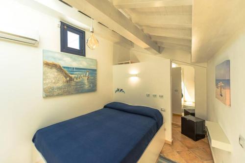 ein Schlafzimmer mit einem blauen Bett und einem Gemälde an der Wand in der Unterkunft Design loft Marinella in Porticello in Santa Flavia