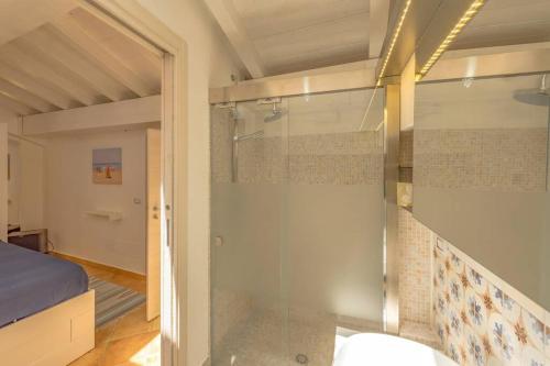 eine Glasdusche in einem Zimmer mit einem Bett in der Unterkunft Design loft Marinella in Porticello in Santa Flavia