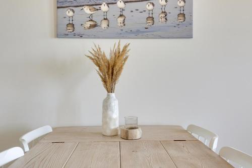 a wooden table with a vase with a candle and a glass at DE TRINTEL met zeezicht in Egmond aan Zee